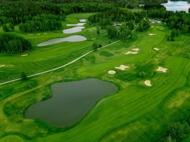 Finlandiya 'da göletli golf sahasında yeşil çimlerin havadan görünüşü