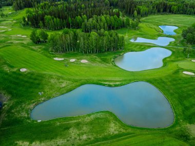 Finlandiya 'da göletli golf sahasında yeşil çimlerin havadan görünüşü