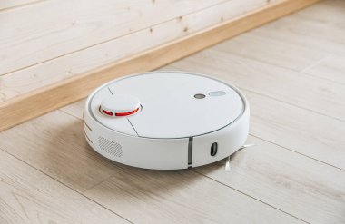 Kablosuz robot elektrik süpürgesi ahşap zeminde çalışıyor. Akıllı ev teknolojileri.