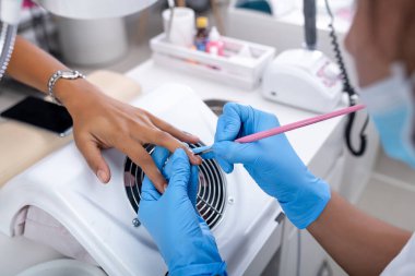 Müşterinin tırnaklarına jel cilası sürüyorum.