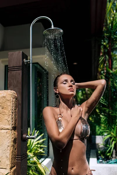 Sexy hermosa morena toma una ducha al aire libre — Foto de Stock