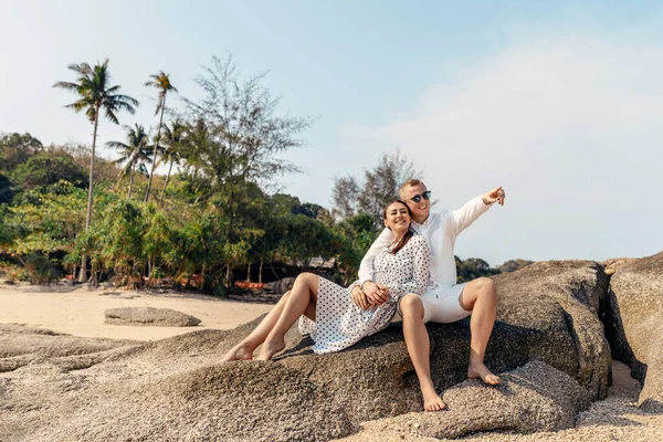 Atractiva pareja joven sentada en la playa — Foto de Stock