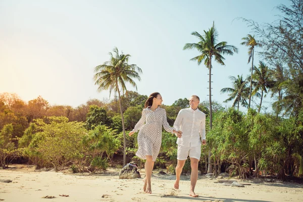 Coppia di spiaggia a piedi in viaggio romantico luna di miele vacanze estive romanticismo. Giovani amanti felici, donna e uomo che si tengono per mano abbracciandosi all'aria aperta. — Foto Stock