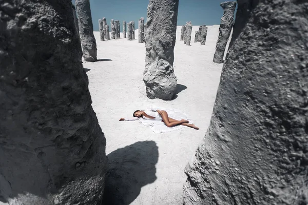 Portrait de jeune belle femme en bikini blanc couché près des rochers dans le désert. Concept vacances d'été, — Photo
