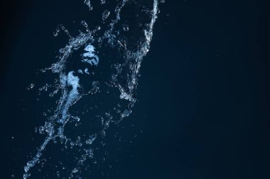 Koyu mavi arkaplanda su sıçraması.