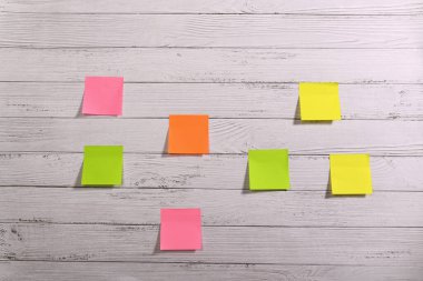 Beyaz ahşap bir masada bir sürü renkli çıkartma var..