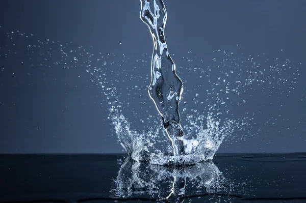 Water Splash On The dark blue background. — Stock Photo, Image