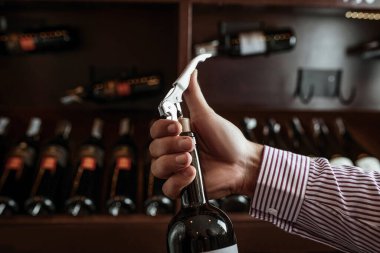 A professional sommelier demonstrates his skills by smelling a cork from a freshly opened wine drink. Sommelier. clipart