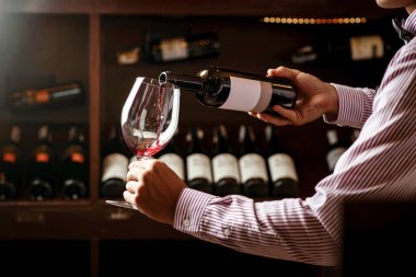 Profesyonel bir şarap garsonu yeteneğini yeni açılmış bir şarap şişesinin mantarını koklayarak gösterir. Sommelier..