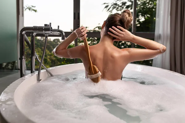 A mulher luxuosa da aparência de modelo toma um banho. Tratamentos Spa — Fotografia de Stock