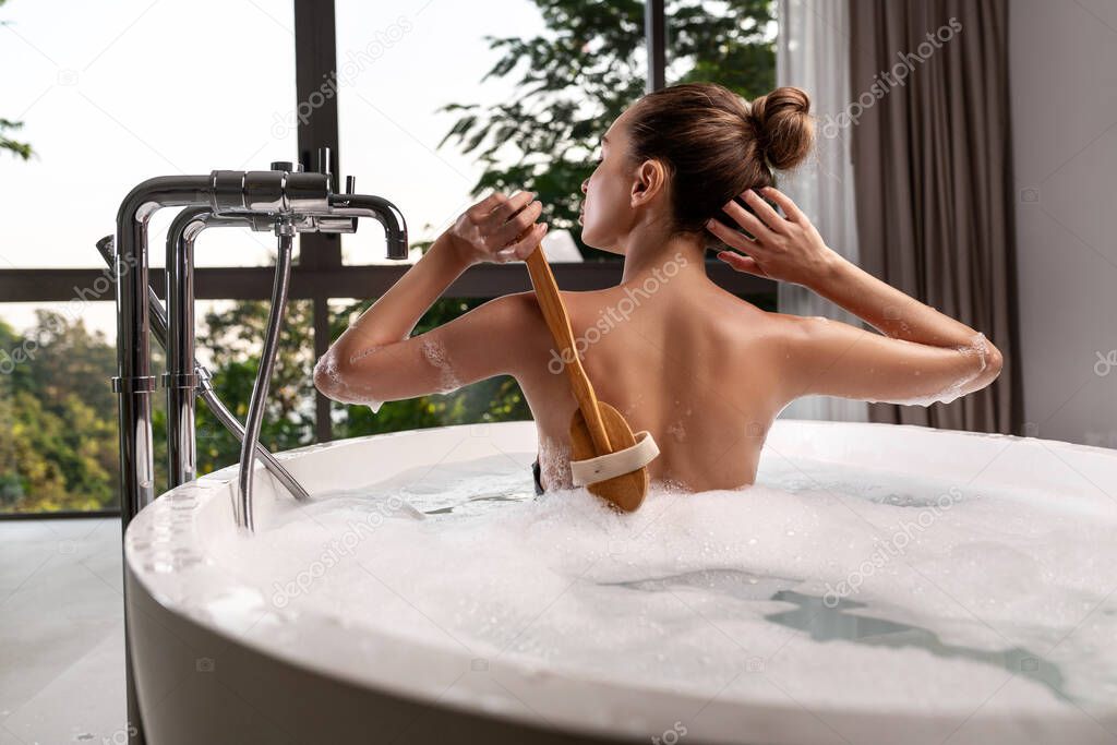 Luxurious woman of model appearance takes a bath. Spa treatments