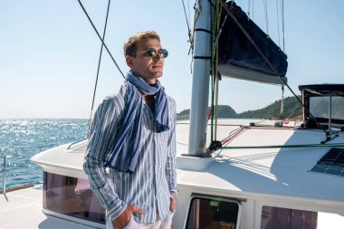 Yakışıklı bir adam yelkenli yatıyla seyahat eder..