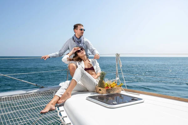 Appuntamento di lusso su uno yacht. Champagne e frutta tropicale. Bello uomo e donna. — Foto Stock