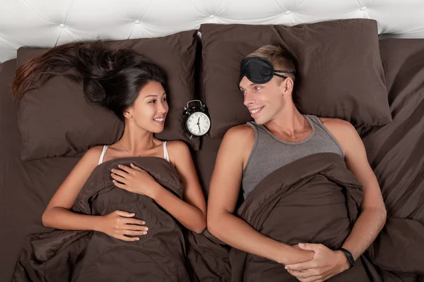 Jovem Casal Satisfeito Está Deitado Cama Despertador Deitado Entre Eles — Fotografia de Stock