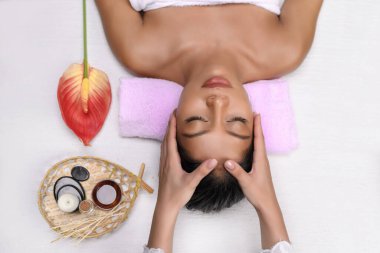 Masör, tatlı ırklar arası bir kızın kafasına gözleri kapalı masaj yapıyor.