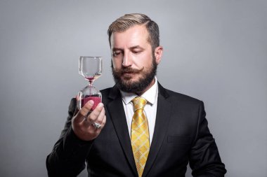 İş adamı kum saati bardaklarını elinde tutuyor. iş zamanı kavramı.