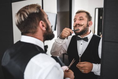 Aynanın önünde traş ol. Genç bir adam sakalını çelik bir bıçakla tıraş ediyor.