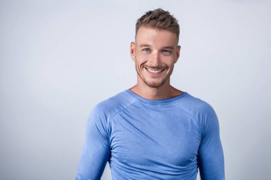 Beyaz arka planda tek başına duran mavi gömlekli yakışıklı iş adamı.