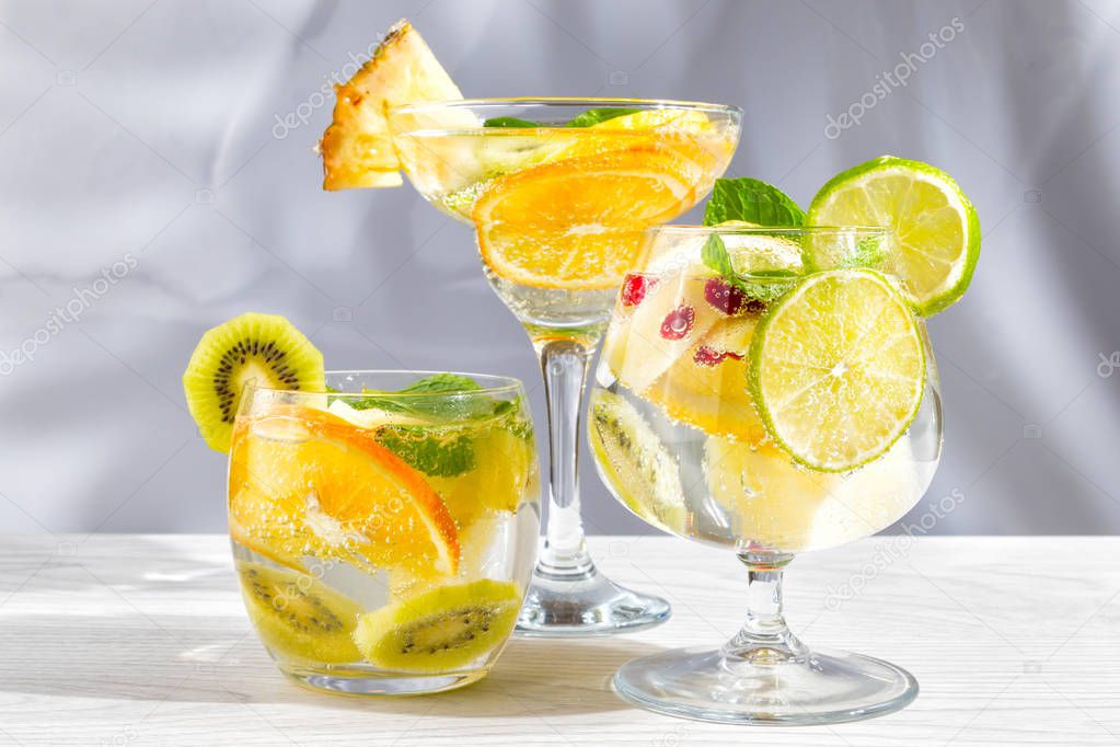 Three different glasses with cocktails with fruits and berries