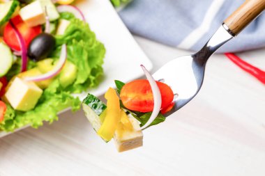 Çatalda hafif yaz sebze salatası. Yakın çekim, üst görünüm.