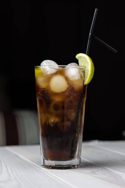 Bir dilim limon ve buziçeren alkollü kokteyl kafe masasında