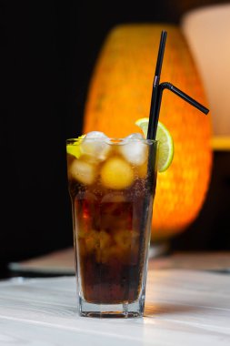 Bir dilim limon ve buziçeren alkollü kokteyl kafe masasında