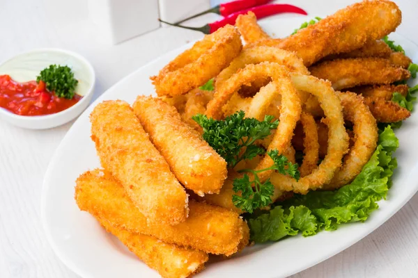 Fried squid rings with cheese sticks on a white plate