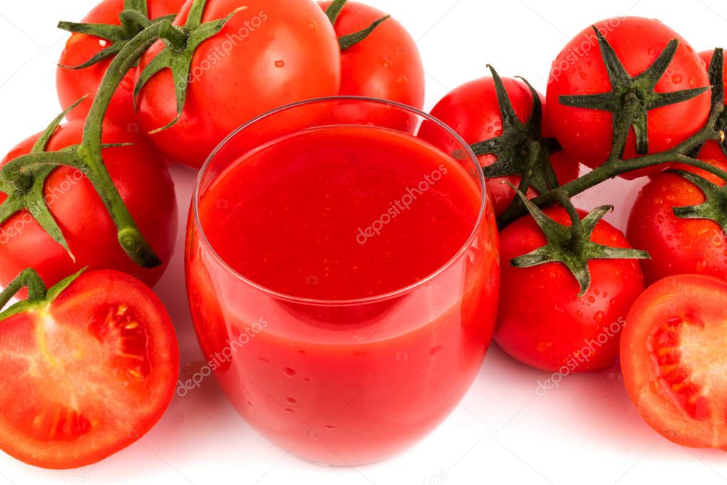 A glass of tomato juice with fresh ripe tomatoes on a white background. Close up