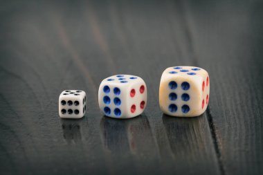 koyu bulanık arka plan üzerinde farklı boyutlarda üç zar. Tonda