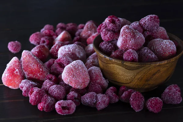 Dondurulmuş çilek, çilek, ahududu koyu bir arka plan yakın çekim