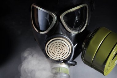 Dumanın içinde gaz maskeli bir adam. Close