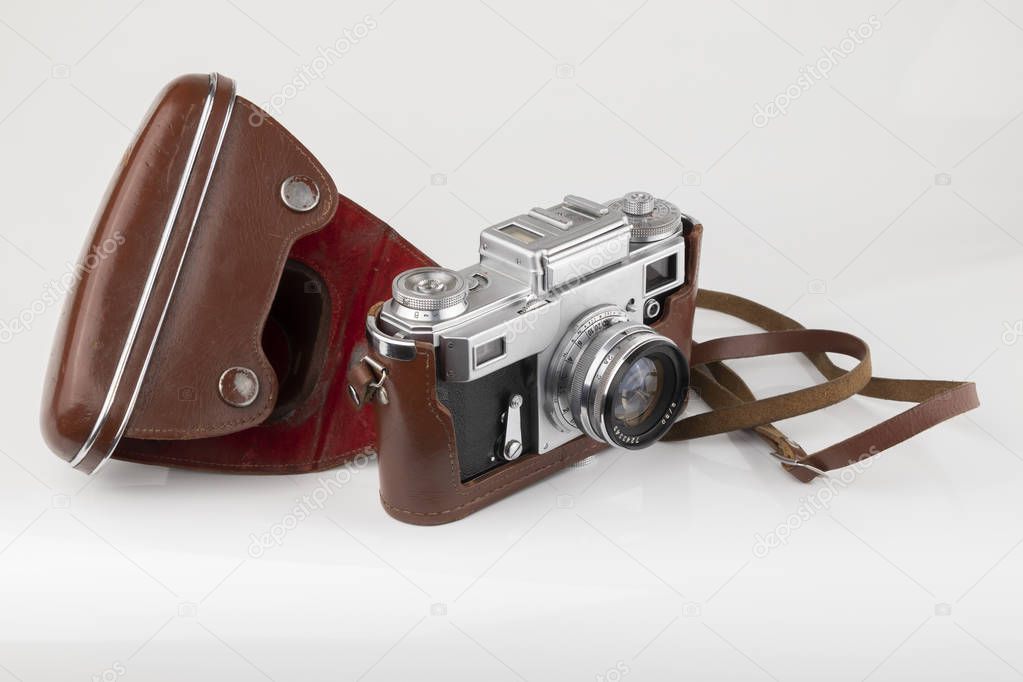 Old vintage photo camera in a leather case on a white background