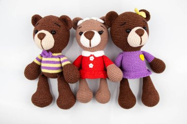 Beyaz arka planda üç komik oyuncak ayı. Amigurumi oyuncağı. Tığ işi doldurulmuş hayvanlar..