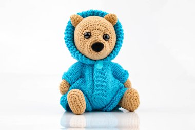 Beyaz arka planda el yapımı komik bir oyuncak ayı. Amigurumi oyuncağı. Tığ işi doldurulmuş hayvanlar.