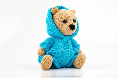 Beyaz arka planda el yapımı komik bir oyuncak ayı. Amigurumi oyuncağı. Tığ işi doldurulmuş hayvanlar.