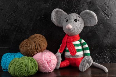Karanlık bir arka planda komik örülmüş oyuncak fare, 2020 yılının bir sembolü. Amigurumi oyuncağı. Tığ işi doldurulmuş hayvanlar..
