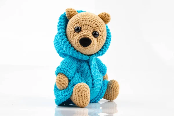 Beyaz arka planda el yapımı komik bir oyuncak ayı. Amigurumi oyuncağı. Tığ işi doldurulmuş hayvanlar.