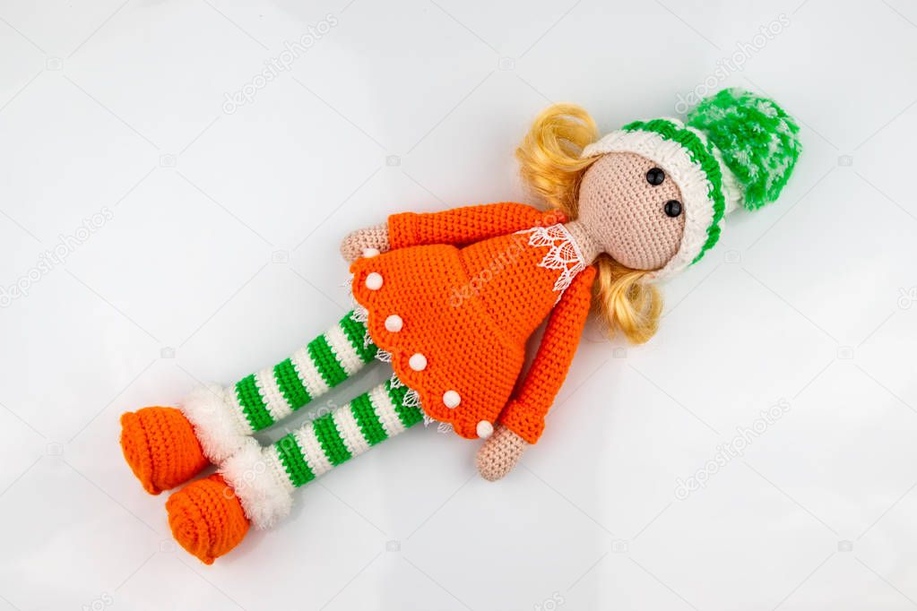 Knitted doll on a white background. Amigurumi toy. Crochet stuffed animals.