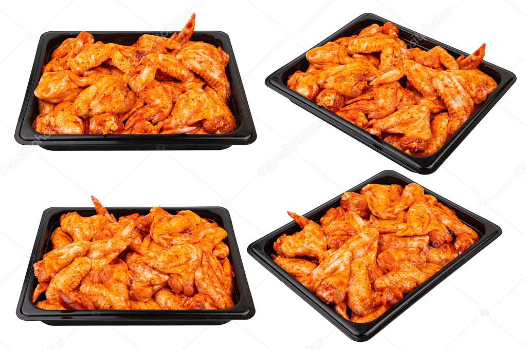 Marinated chicken wings in a black plastic container Ready for sale. White isolated.