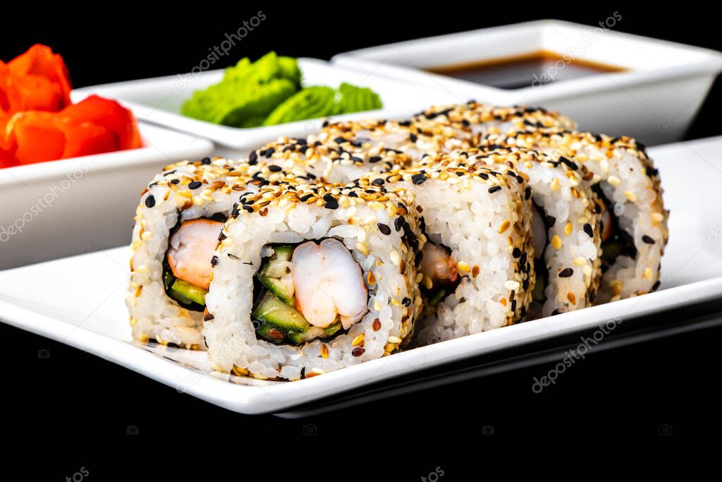 Rolls with shrimp, cucumber, avocado and sesame seeds on a white plate on a dark background. Sushi menu. Japanese food.