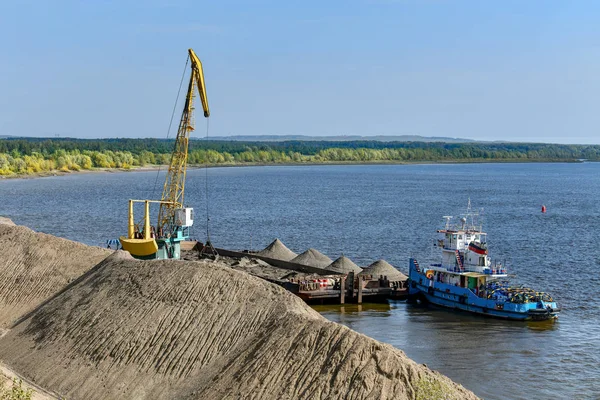 Loading sand and gravel on a barge.