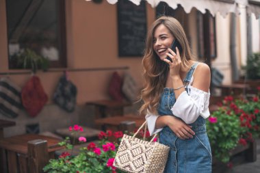 Cep telefonu ile konuşurken kafede oturan oldukça duygusal mutlu kız görüntü..
