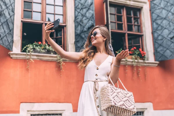 Genç kız almak selfie elinden telefon ile yaz şehir sokak