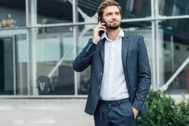 Akıllı telefon kullanan takım elbiseli yakışıklı bir adam.
