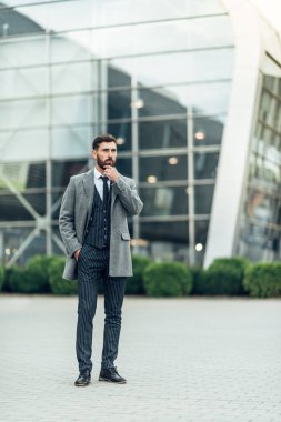 Yakışıklı bir adam elini çenenin yanında tutar.