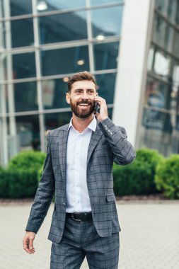 cep telefonu kullaranarak gülümseyen iş adamı