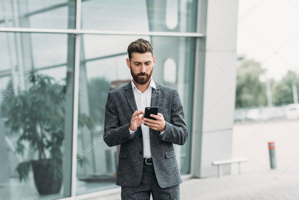 Businessman texting messages while walking