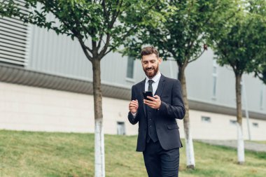 cep telefonu kullaranarak gülümseyen iş adamı