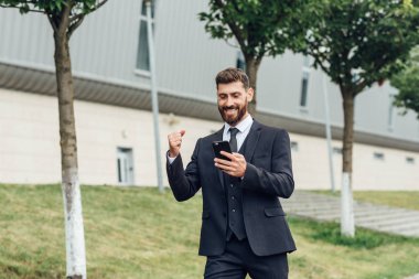 cep telefonu kullaranarak gülümseyen iş adamı