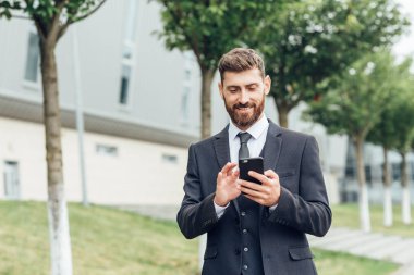 Sokakta cep telefonuyla konuşan genç iş adamı.